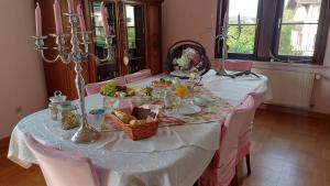 a table with a white table cloth and a basket of food at Zum Alten Pfarrhaus in Damscheid
