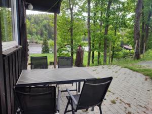 a table and chairs on the porch of a house at Strandheim Two-Bedroom Cottage in Birkeland