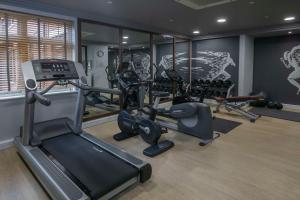 een fitnessruimte met diverse loopbanden en hometrainers bij DoubleTree by Hilton Stratford-upon-Avon, United Kingdom in Stratford-upon-Avon