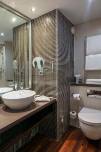 a bathroom with a sink and a toilet at DoubleTree by Hilton Stratford-upon-Avon, United Kingdom in Stratford-upon-Avon