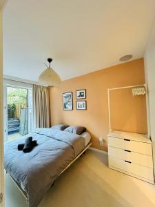 a bedroom with a bed and a dresser and a window at Hotel Hoofd & Vondel in Amsterdam