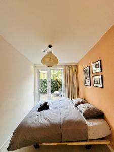 Hotel Hoofd & Vondel في أمستردام: غرفة نوم بسرير ممدد عليها قطة سوداء