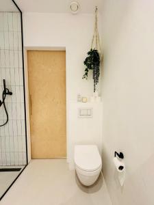 a white bathroom with a toilet and a door at Hotel Hoofd & Vondel in Amsterdam