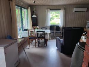 a kitchen and living room with a table and chairs at Strandheim Two-Bedroom Cottage in Birkeland