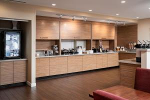 duża kuchnia z drewnianymi szafkami i urządzeniami w obiekcie TownePlace Suites by Marriott Cleveland w mieście Cleveland