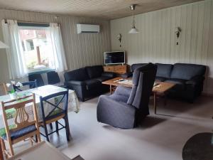 ein Wohnzimmer mit einem Sofa und einem Tisch in der Unterkunft Strandheim Two-Bedroom Cottage in Birkeland