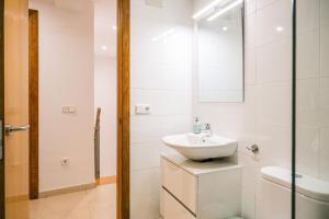 a white bathroom with a sink and a mirror at Ca lEudald 1 Descubre Besalú en familia in Besalú