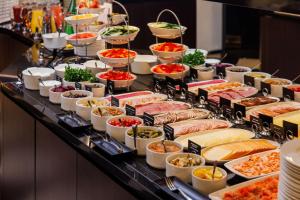 una línea de buffet con muchos tipos diferentes de comida en Palace Hotel Tallinn, a member of Radisson Individuals en Tallin