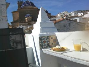 a plate of food on a balcony with a drink at Cute and characterful townhouse in Oliva