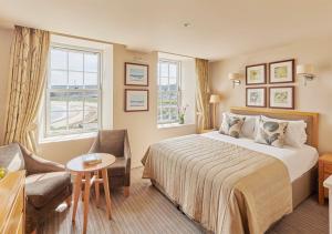 Cette chambre comprend un grand lit et un canapé. dans l'établissement Braye Beach Hotel, à Braye