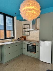 una cucina con frigorifero bianco e lampadario pendente di Wergelandshaugen a Eidsvoll