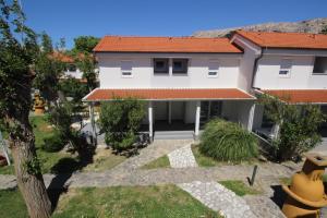 a large white house with red roof at Villas Corinthia in Baška