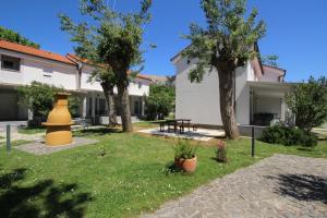 a yard with two trees and a yellow vase at Villas Corinthia in Baška