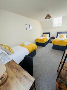 um quarto com 2 camas e uma mesa de madeira em Leicester City 4 Bed home em Leicester