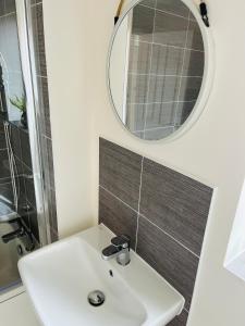 y baño con lavabo blanco y espejo. en Leicester City 4 Bed home, en Leicester