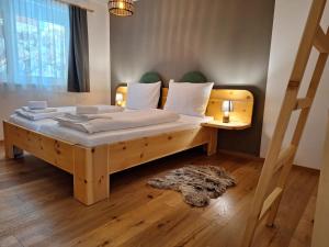 a bedroom with a large wooden bed with white sheets at Luxescape- Turracher Höhe- Chalet Apartement Almzeit- FeWo Maierbrugger - Sauna - Parkplatz - WLAN- Naturschutzgebiet in Brandstätter