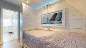 Un dormitorio con una cama y un cuadro en la pared. en Inselloft, en Hörnum
