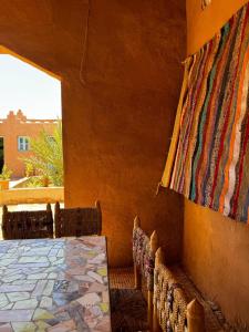 a room with a table and chairs and a window at Auberge Sahara Iriki & Désert Tours in Foum Zguid