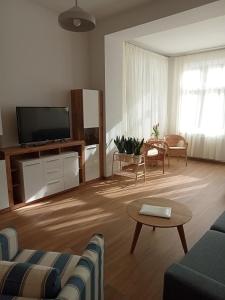 sala de estar con sofá y TV en Haus Troja, en Warnemünde