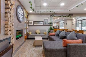 ein Wohnzimmer mit Sofas und einer Uhr an der Wand in der Unterkunft Country Inn & Suites by Radisson, Newport News South, VA in Newport News