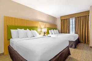 2 camas blancas grandes en una habitación de hotel en Country Inn & Suites by Radisson, Newport News South, VA, en Newport News