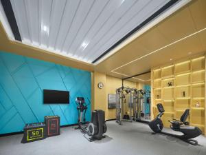 a gym with tread machines and a television in a room at Hilton Garden Inn Aksu Downtown in Aksu