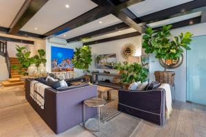 a living room with couches and potted plants at Clifton Ezulwini in Cape Town