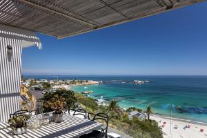 a balcony with a view of a beach and the ocean at Clifton Ezulwini in Cape Town