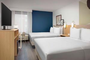 ein Hotelzimmer mit 2 Betten und einem Flachbild-TV in der Unterkunft Spark by Hilton Atlanta Cumberland Ballpark in Atlanta