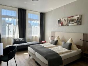 een hotelkamer met een bed en een bank bij City Hotel Hameln in Hameln