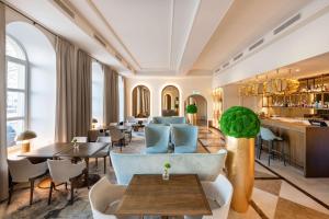 a hotel lobby with tables and chairs and a bar at Grand Hotel Vilnius, Curio Collection by Hilton in Vilnius