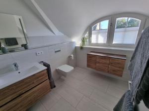a bathroom with a sink and a toilet and a window at Landhaus Wreechen mit Dachterrasse in Putbus +9 photos