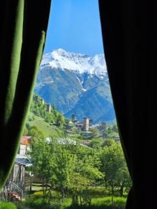 a view of a snow covered mountain from a window at B&B Cottage in Mestia in Mestia