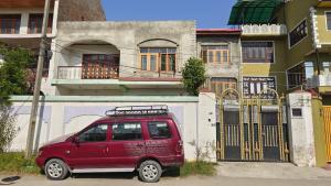 un furgone rosso parcheggiato di fronte a un edificio di Mir manzil a Srinagar