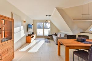 a living room with a table and a couch at Landhaus Wreechen mit Dachterrasse in Putbus