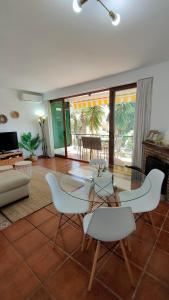 a living room with a glass table and chairs at M&H Torremolinos in Torremolinos