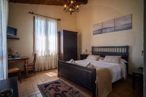 Il Castellaro في Borghi: غرفة نوم بسرير ومكتب ونافذة