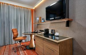 a hotel room with a table and a television at Hilton London Tower Bridge in London