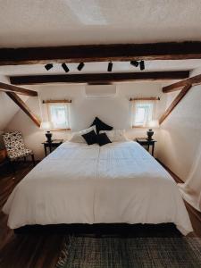 a bedroom with a white bed and two windows at Weingut Holler Chalet Weingarten in Spielfeld