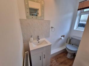 ein Badezimmer mit Waschbecken, Toilette und Spiegel in der Unterkunft Cooks House by Cliftonvalley Apartments in Bristol + 47 Fotos