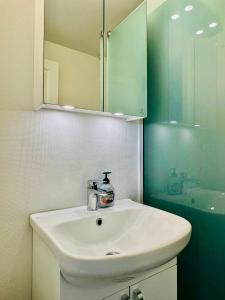 a bathroom with a white sink and a mirror at 5 minute walk to LEGO house - 50m2 cozy apartment- D unit in Billund