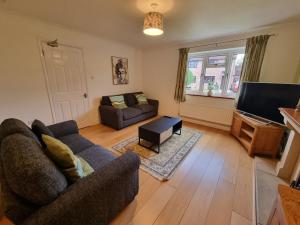 ein Wohnzimmer mit Sofa und Fernseher in der Unterkunft Cooks House by Cliftonvalley Apartments in Bristol