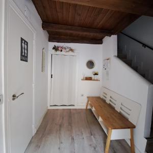 un pasillo con un banco de madera y escaleras en La Encina del Abuelo, en La Adrada