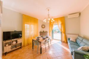a living room with a couch and a table and a tv at Berardino Holiday House in Ravello
