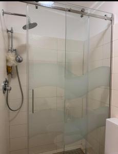 La salle de bains est pourvue d'une douche avec une porte en verre. dans l'établissement YONO apartment, à La Spezia