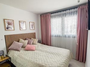 Un dormitorio con una cama con almohadas rosas y una ventana. en Casa de Jazz, en El Verger 40 fotos más
