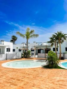 una piscina frente a una casa con palmeras en Casa de Jazz, en El Verger