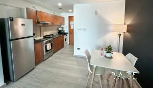 a kitchen with a white table and a refrigerator at Rare Holiday Homes - Studio in Crescent Tower near City Center Mall - R712 IMPZ in Dubai