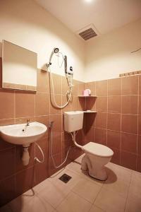 a bathroom with a shower and a toilet and a sink at BMW Hotel in Muar