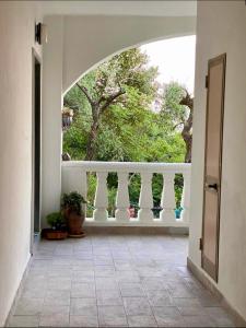 un couloir ouvert avec un balcon et un arbre dans l'établissement YONO apartment, à La Spezia